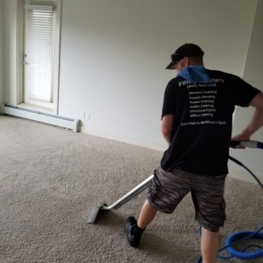 Man carpet cleaning a room